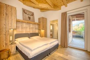een slaapkamer met een bed en een balkon bij Penthouse Ski & Golf - by Alpen Apartments in Zell am See