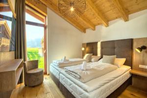 a bedroom with two beds and a large window at Ski-in Ski-out Chalet Maiskogel 17A - by Alpen Apartments in Kaprun