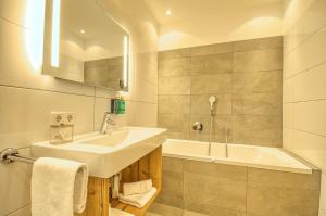 a bathroom with a sink and a bath tub at Penthouse Ski & Golf - by Alpen Apartments in Zell am See