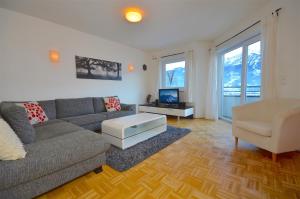 皮森多夫的住宿－Panoramic View - by Alpen Apartments，客厅配有沙发、椅子和电视