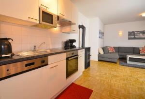 cocina y sala de estar con sofá en Panoramic View - by Alpen Apartments, en Piesendorf