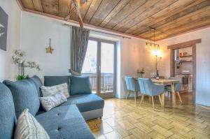 a living room with a blue couch and a table at Haus Kitzsteinhorn 7 - by Alpen Apartments in Kaprun