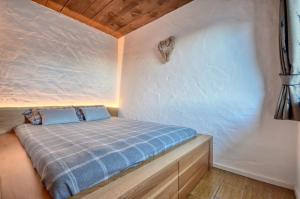 a small bedroom with a bed in the corner at Haus Kitzsteinhorn 7 - by Alpen Apartments in Kaprun
