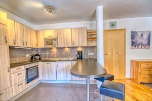 - une cuisine avec des placards en bois et une table dans l'établissement Apartment Dunn - by Alpen Apartments, à Bad Gastein