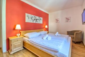 a bedroom with a bed with a red wall at Apartment Dunn - by Alpen Apartments in Bad Gastein