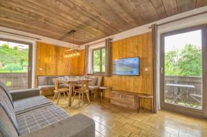 - un salon avec une table et une télévision dans l'établissement Haus Kitzsteinhorn 6 - by Alpen Apartments, à Kaprun