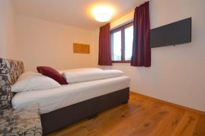 a small bedroom with a bed and a window at Ski-in Ski-out Chalet Maiskogel 13A - by Alpen Apartments in Kaprun