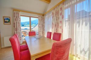 jadalnia z drewnianym stołem i czerwonymi krzesłami w obiekcie Apartment Central - by Alpen Apartments w mieście Zell am See