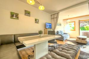 ein Wohnzimmer mit einem Tisch und einem Sofa in der Unterkunft Apartment Valentina - by Alpen Apartments in Zell am See