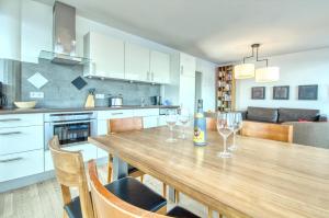 ツェル・アム・ゼーにあるAPT Super Zell -by Alpen Apartmentsのキッチン(木製テーブル、ワイングラス付)