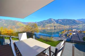 uma vista para um lago a partir da varanda de uma casa em APT Super Zell -by Alpen Apartments em Zell am See