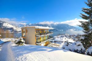 um edifício no topo de uma montanha coberta de neve em APT Super Zell -by Alpen Apartments em Zell am See