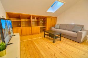 a living room with a couch and a tv at Mozart Top 3 - by Alpen Apartments in Zell am See