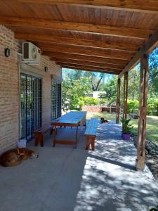 un patio avec une table de pique-nique et un chien allongé sur le sol dans l'établissement Casa de descanso y naturaleza, à Paso de la Patria