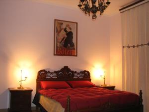 a bedroom with a red bed with a picture on the wall at B&B Itala in Recanati