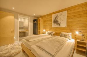 a bedroom with two beds and a bathroom at Gletscherblick 1 - by Alpen Apartments in Zell am See