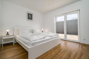 Un dormitorio blanco con una cama grande y una ventana. en Ferienhaus Schilfblick, en Buchholz