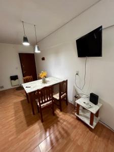 een eetkamer met een tafel en een televisie aan de muur bij Departamento en microcentro de la ciudad in Mendoza