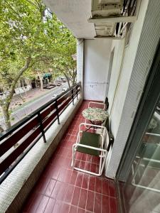 een balkon met een tafel en stoelen en een straat bij Departamento en microcentro de la ciudad in Mendoza