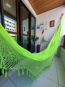 a green hammock hanging in a room at Apartamentos 250m da Orla -Edifício Nugali- Castelo B Temporada in Maceió