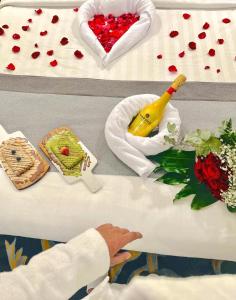 - une table avec des cœurs rouges et une bouteille de champagne dans l'établissement Laten Suites Prince Sultan, à Djeddah