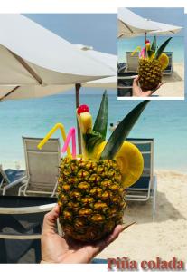 a person holding a pineapple in the air on the beach at Tours Mandala Beach in Baru
