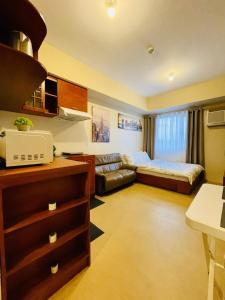a hotel room with a bed and a couch at City View Studio Unit at Aspira Tower 1 in Cagayan de Oro