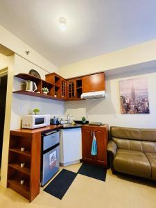a small kitchen with a couch and a microwave at City View Studio Unit at Aspira Tower 1 in Cagayan de Oro