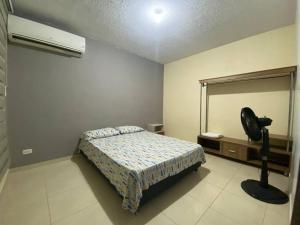 una camera con letto, specchio e ventilatore di Apartamento completo con aire en Valledupar a Valledupar