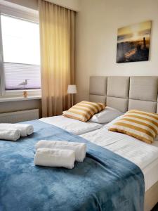 Duas camas num quarto com toalhas em Willa Plażowa em Rewa