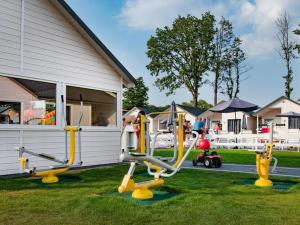 a group of playground equipment in the grass next to a house at Holiday cottages, pool, whirlpool, D bki in Dąbki