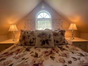 a bedroom with a bed with pillows and a window at High Hill Inn in Montpelier