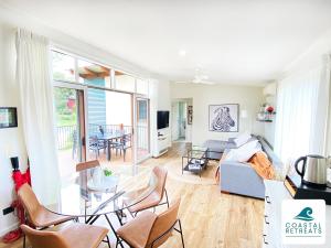 sala de estar con sofá, mesa y sillas en Woodland Retreat - Phillip Island - Ramada Resort, en Cowes