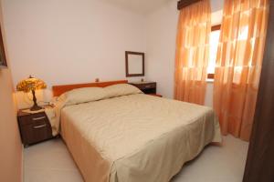 a bedroom with a bed and a lamp and a window at Apartments with a parking space Mocici, Dubrovnik - 9081 in Mlini