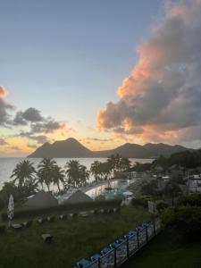 a view of the ocean from a resort at sunset at Appart chambre et salon in Le Diamant