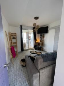 a living room with a couch and a table at Appart chambre et salon in Le Diamant