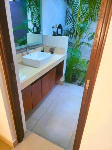 a bathroom with a sink and a palm tree at Casa Don Willo in Escuintla
