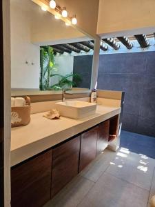 een badkamer met een wastafel en een spiegel bij Casa Don Willo in Escuintla