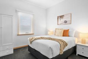 a white bedroom with a bed and a window at LuCo House Stanley in Stanley