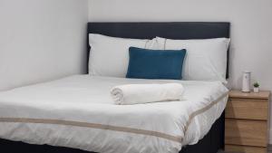 um quarto com uma cama com uma almofada azul em Brand new collection of studios close to Tube Station em Londres
