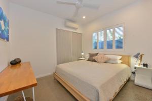 een slaapkamer met een bed en een raam bij Tropical Villa on Craven Close in Port Douglas