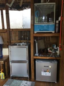a kitchen with a sink and a refrigerator at Kubo A M&K's Guesthouse in Dauis
