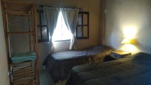 a small bedroom with two beds and a window at Angiru in Mercedes