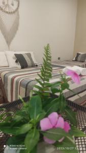 a bedroom with a bed and a plant with pink flowers at Quinta Rosita in Ticul