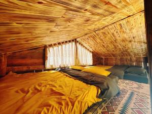 Cette chambre comprend un grand lit et un plafond en bois. dans l'établissement Homestay KV Houses - Cầu Đất, à Xuân Trường