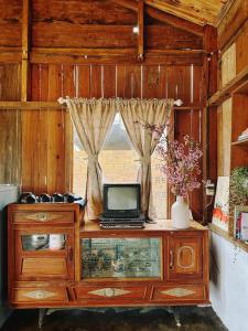 - une télévision installée au-dessus d'un meuble en bois dans l'établissement Homestay KV Houses - Cầu Đất, à Xuân Trường