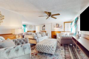 uma sala de estar com sofás e uma ventoinha de tecto em Coastal Charm on the Cape em Centerville
