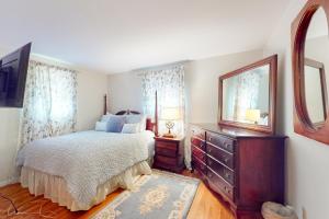 um quarto com uma cama, uma cómoda e um espelho em Coastal Charm on the Cape em Centerville