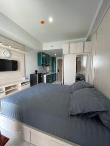 a bedroom with a large bed and a kitchen at Delft Apartment - Sea View Studio Flat at Losari Beach in Makassar