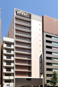 a tall white building with many windows at Sanco Inn Grande Tokyo Hamamatsucho in Tokyo